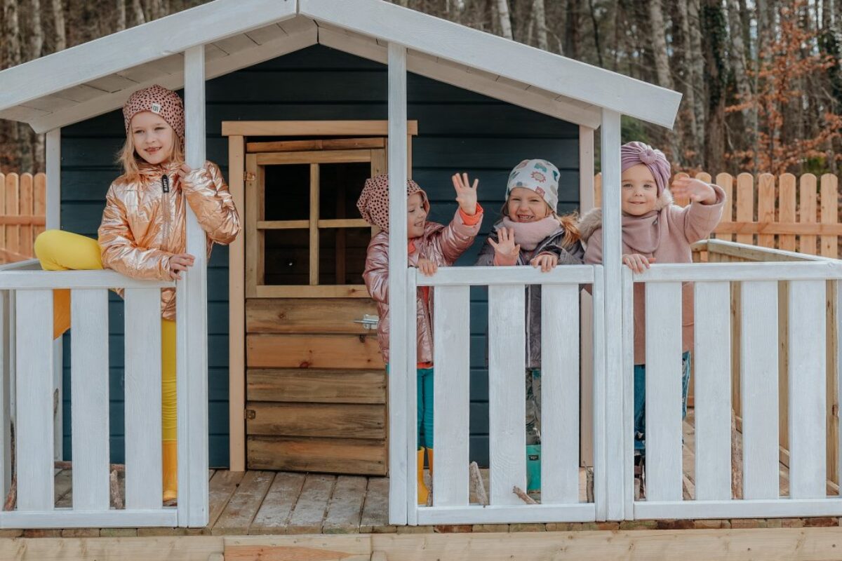 Dzieci bawiące i cieszące się w małym domku do zabaw.